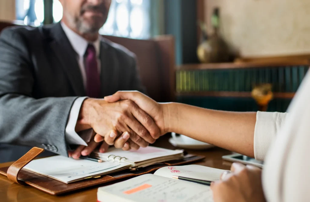 Business handshake across a desk during a meeting