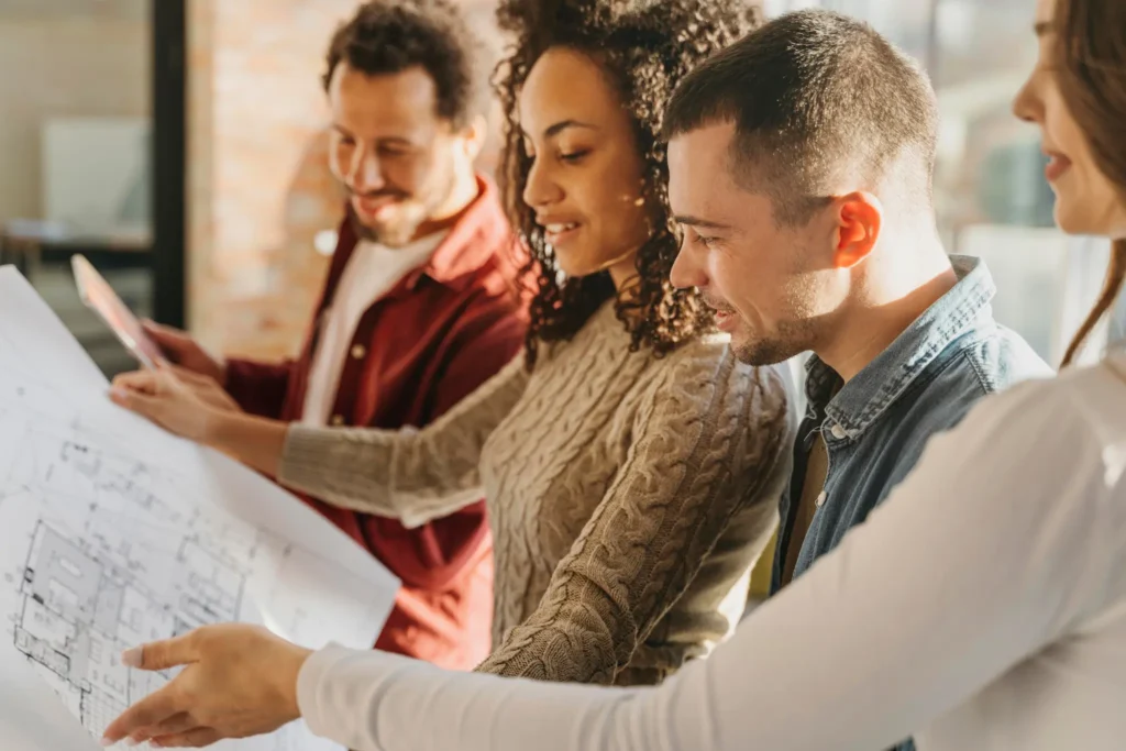Team reviewing architectural blueprints together in a sunlit office